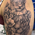 Tatto of Lioness and Cub with flowers collaged in a custom design tattoo